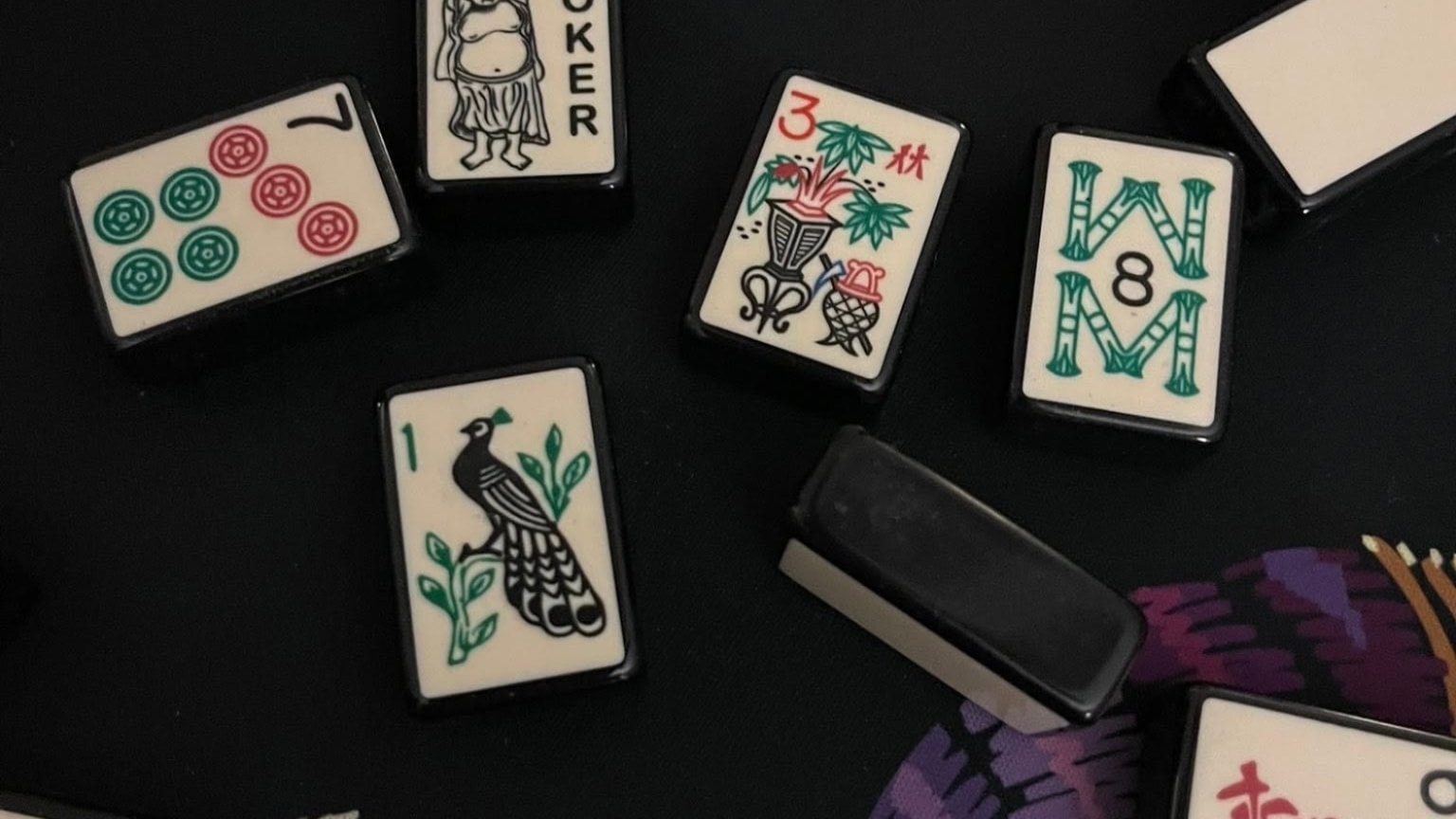 Minimalist black mahjong tiles with stark white faces on dark surface